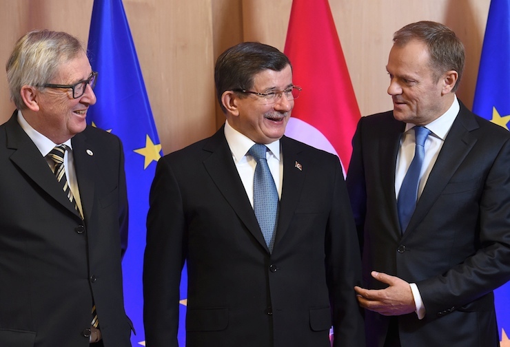 Turkish Prime Minister Davutoglu is welcomed by European Commission President Juncker and European Council President Tusk during an EU-Turkey summit in Brussels