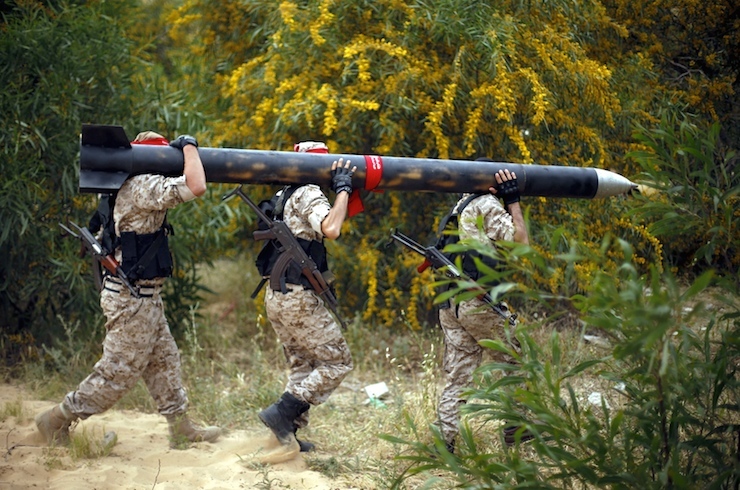Palestinian militants show a home-made rocket to the media during an anti-Israel joint drill in Khan Younis in the southern Gaza Strip