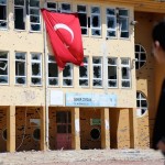 A boy stands in front of a primary school, which was damaged during the security operations and clashes between Turkish security forces and Kurdish militants, in the southeastern town of Idil