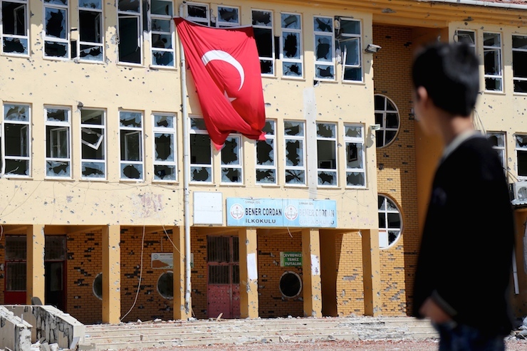 A boy stands in front of a primary school, which was damaged during the security operations and clashes between Turkish security forces and Kurdish militants, in the southeastern town of Idil, Turkey, March 31, 2016. REUTERS/Sertac Kayar TPX IMAGES OF THE DAY