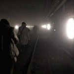 Passengers walk on underground metro tracks to be evacuated after an explosion at Maelbeek train station in Brussels, Belgium