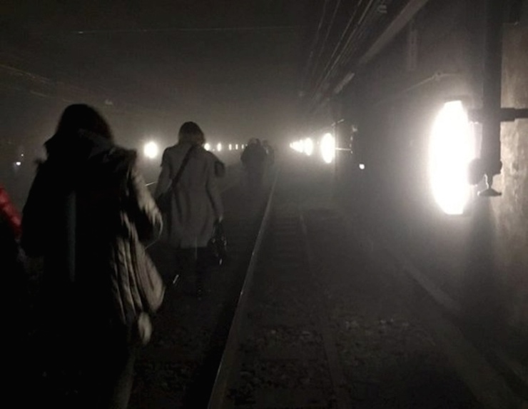 Passengers walk on underground metro tracks to be evacuated after an explosion at Maelbeek train station in Brussels, Belgium