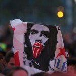 Fans hold an image of late revolutionary hero Ernesto “Che” Guevara with the symbol of the British band Rolling Stones before their free outdoor concert at Ciudad Deportiva de la Habana sports complex in Havana