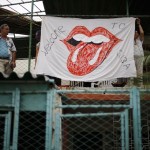 Fans hang up a banner on a terrace outside the Ciudad Deportiva de la Habana sports complex where the Rolling Stones' free outdoor concert will take place today in Havana