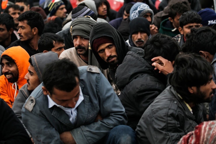 Refugees and migrants wait to be transferred to the Moria registration centre after arriving at the port of Mytilene on the Greek island of Lesbos, following a rescue operation by the Greek Coast Guard at open sea