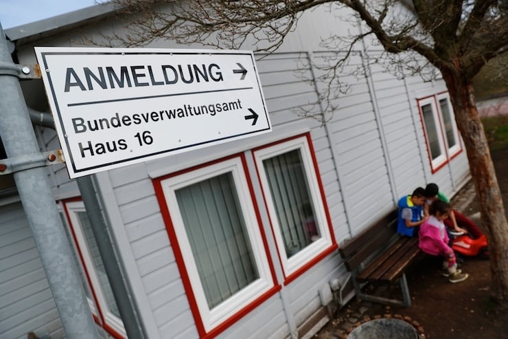 Children play outside a barracks at the camp for migrants and refugees in Friedland