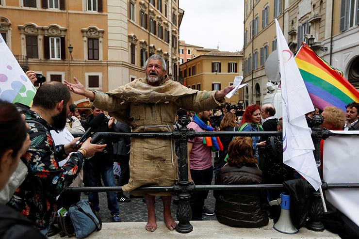 A man protests in front of the Parliament during the final vote on gay and unmarried civil unions at Italy's lower house of Parliament in Rome