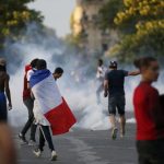Tear gas floats in the air during clashes outside the Paris fan zone during a EURO 2016 final soccer match