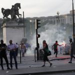 Tear gas floats in the air during clashes outside the Paris fan zone during a EURO 2016 final soccer match