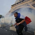 Tear gas floats in the air near the Eiffel Tower outside the Paris fan zone before a EURO 2016 final soccer match
