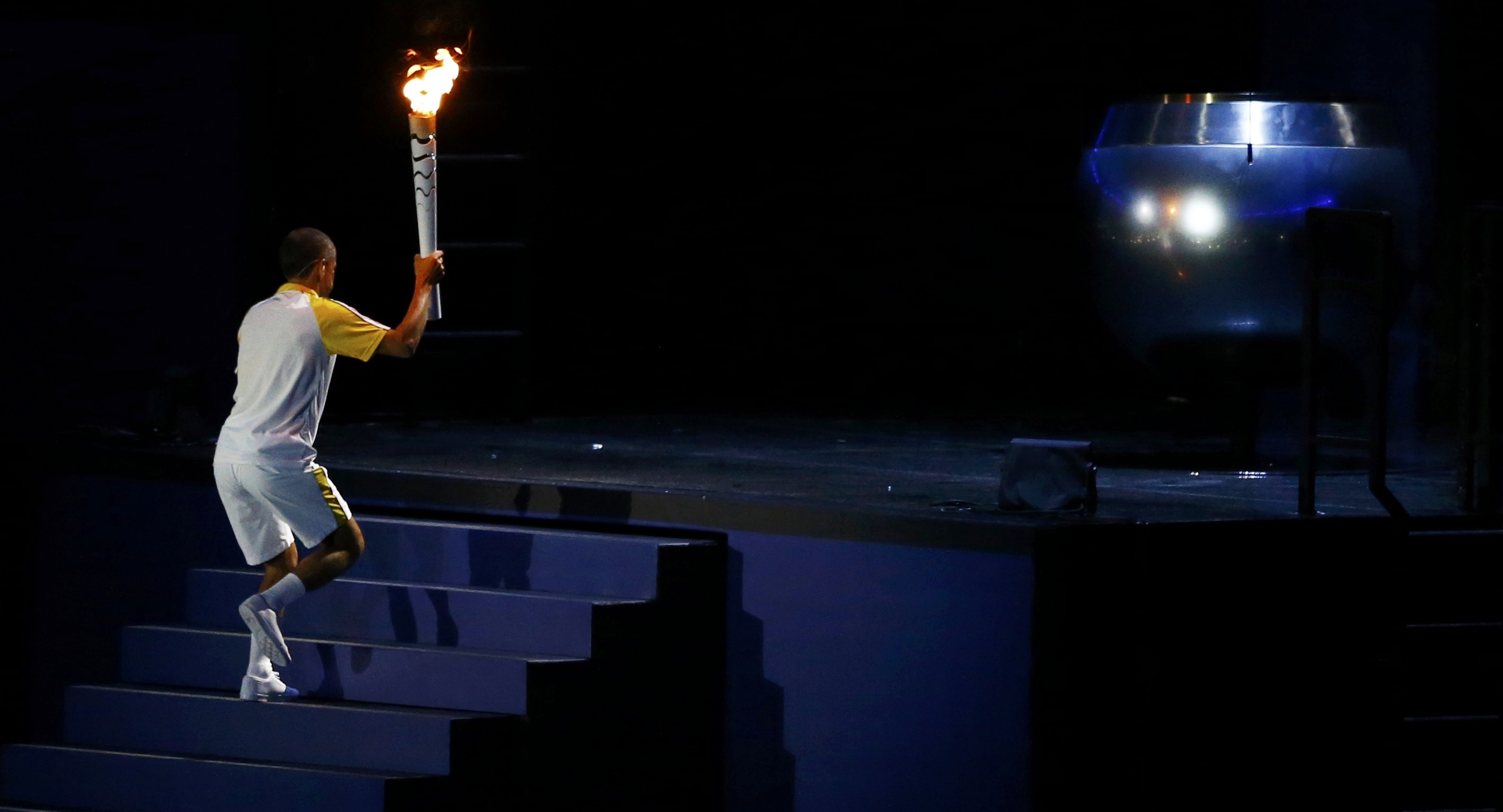 2016 Rio Olympics - Opening ceremony - Maracana - Rio de Janeiro, Brazil - 05/08/2016. Former Brazilian marathon runner Vanderlei Cordeiro de Lima walks up the stairs with the Olympic torch to light the Olympic cauldron at the opening ceremony. REUTERS/Ivan Alvarado FOR EDITORIAL USE ONLY. NOT FOR SALE FOR MARKETING OR ADVERTISING CAMPAIGNS