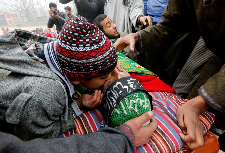 A boy kisses the face of suspected militant Rayees Ahmad Dar, who according to local media was killed in an encounter with the Indian armed forces in Pulwama district on Saturday afternoon, during his funeral in Kakapora village, south of Kashmir