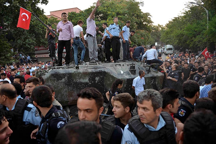 Turkish policemen cordon up around a military vehicle in Ankara