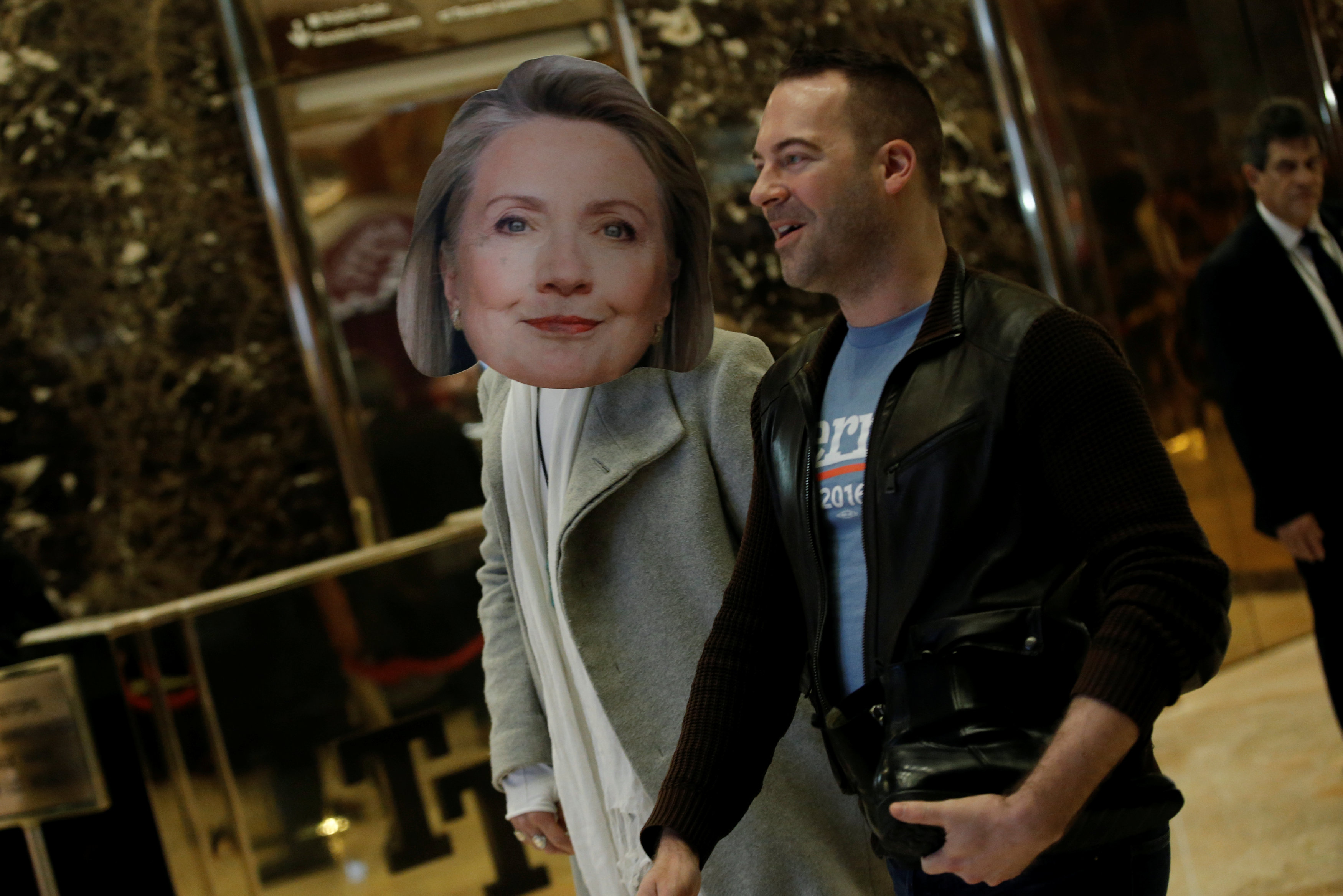 A man wearing a mask of former Democratic presidential candidate Hillary Clinton walks through the lobby of Trump Tower, where U.S. President-elect Donald Trump lives, in New York, U.S. December 8, 2016.   REUTERS/Mike Segar     TPX IMAGES OF THE DAY