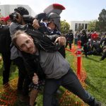 A protestor is pulled from a confrontation by a pro-Trump supporter during the Patriots Day Free Speech Rally in Berkeley, California