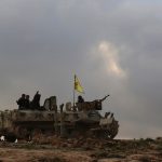 Fighters of the Kurdish People's Protection Units flash victory signs as they ride on an armoured carrier at the mount Sinjar