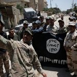 Members of the Iraqi Army's 9th Armoured Division are photographed with an Islamic State flag, claimed after fighting with Islamic State militants in western Mosul