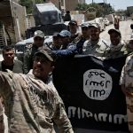 Members of the Iraqi Army's 9th Armoured Division are photographed with an Islamic State flag, claimed after fighting with Islamic State militants in western Mosul