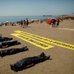 People take part in a performance which simulates the death of immigrants at the Mediterranean Sea and to commemorate the World Refugee Day, in Malaga