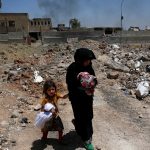 Displaced Iraqi residents flee their homes due to fighting between Iraqi forces and Islamic State militants near the Old City in western Mosul