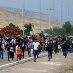 Syrians carry their belongings as they walk to the Turkish Cilvegozu border gate in the southern Hatay province