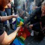 Anti-LGBT protesters burn a rainbow flag during the equality march in Kiev