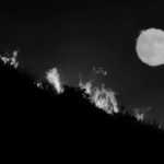 The full moon rises over flames of the Alamo fire on a hilltop off Highway 166 east of Santa  Maria