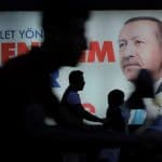 People walk past an election poster for Turkey's President Tayyip Erdogan in Istanbul