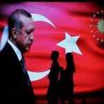 People walk past an election poster for Turkey's President Tayyip Erdogan in Istanbul