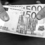 A bank employee holds a pile of 500 euro bank notes in Madrid