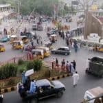 Taliban militants drive past a crowded street at Pashtunistan Square area in Jalalabad