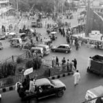 Taliban militants drive past a crowded street at Pashtunistan Square area in Jalalabad