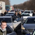 People wait in a traffic jam as they leave the city of Kharkiv