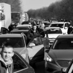 People wait in a traffic jam as they leave the city of Kharkiv