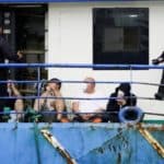 Police officers guard four detainees on the fishing boat “AKT-1”, in the island of Gran Canaria