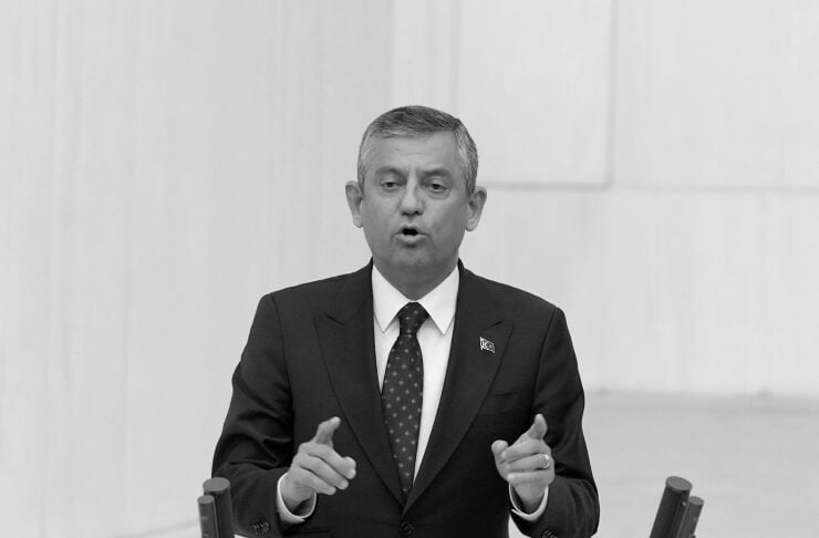 Man in a dark suit speaks at a podium, gesturing with hands, timer reads 00:00:30 in front of him.