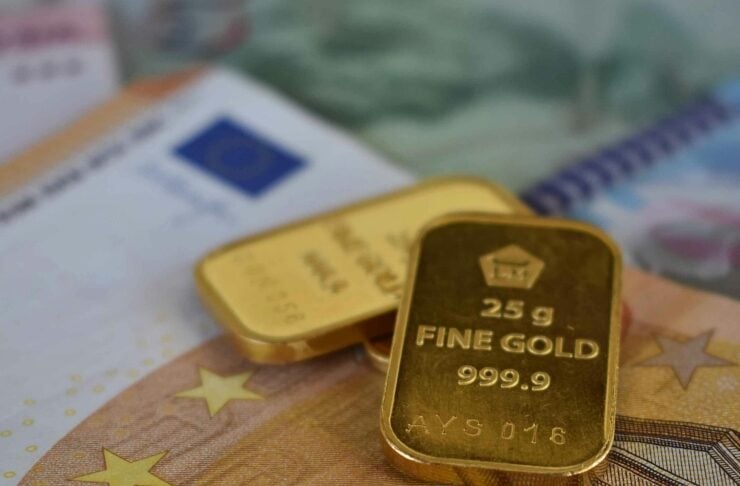 Gold bars resting on Euro banknotes, suggesting wealth and investment symbolism.