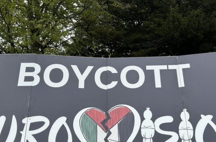 Protest sign reading 'Boycott Eurovision' with a cracked heart logo and the slogan 'Artwashing Israel's #GazaGenocide'.