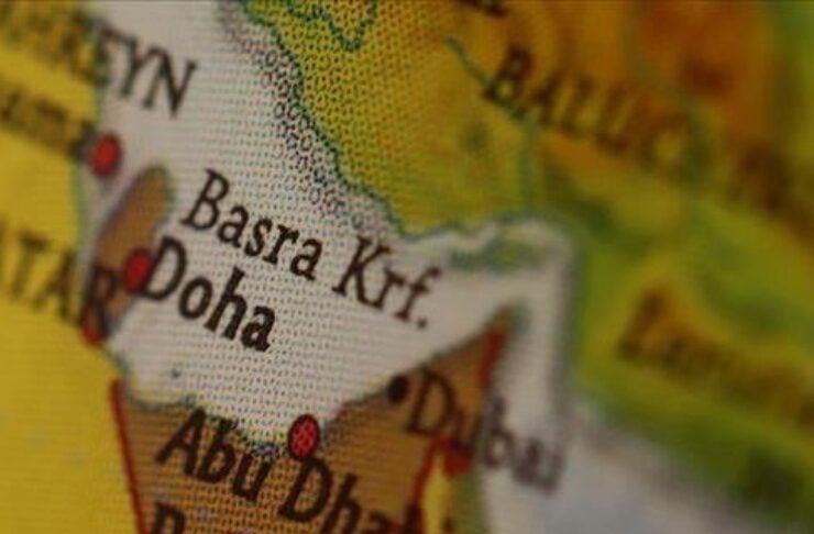 Close-up of a world map focusing on the Persian Gulf with Doha and Abu Dhabi labeled in bold text.
