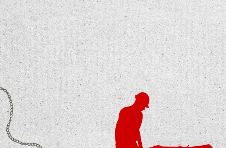 Red silhouette of a worker pushing a wheelbarrow, with a long chain trailing from the worker’s leg.