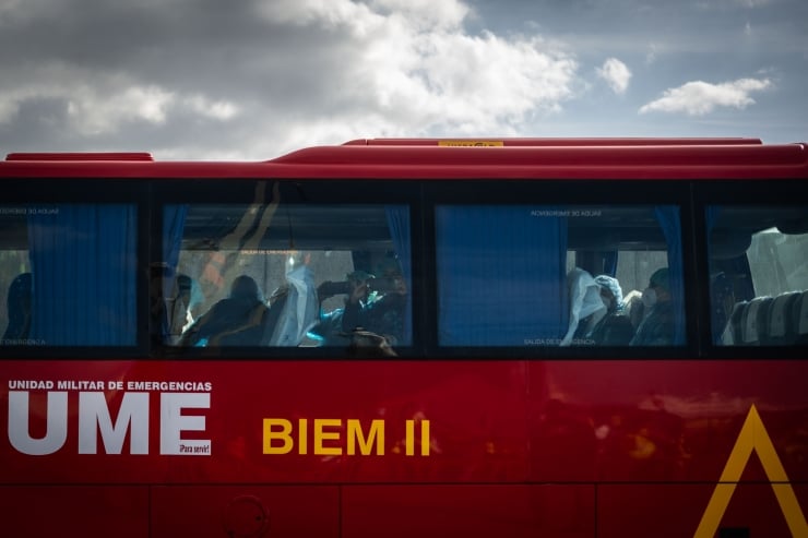 Red emergency services bus with 'UME' and 'BIEM II' markings, passengers visible through the windows