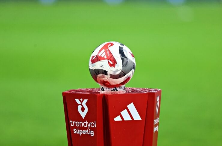 Soccer ball resting on a red pedestal with Trendyol Süper Lig branding, Adidas logo, and a green field in the background