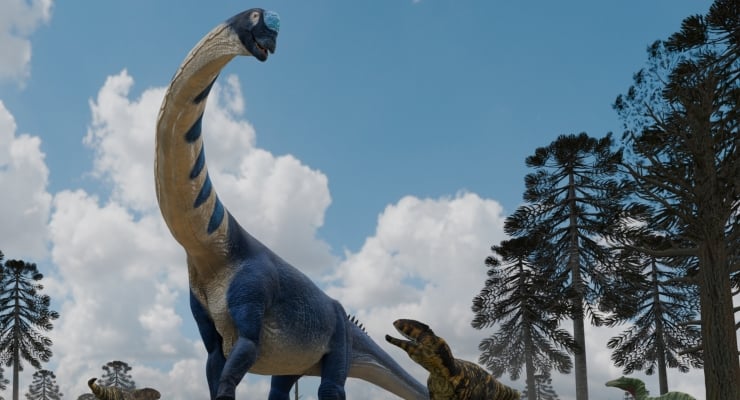 Large blue Brachiosaurus statue in a dinosaur park with trees and clouds in the sky.