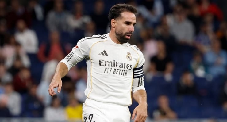 Real Madrid player in a white kit with Emirates sponsor, running on the pitch during a match.