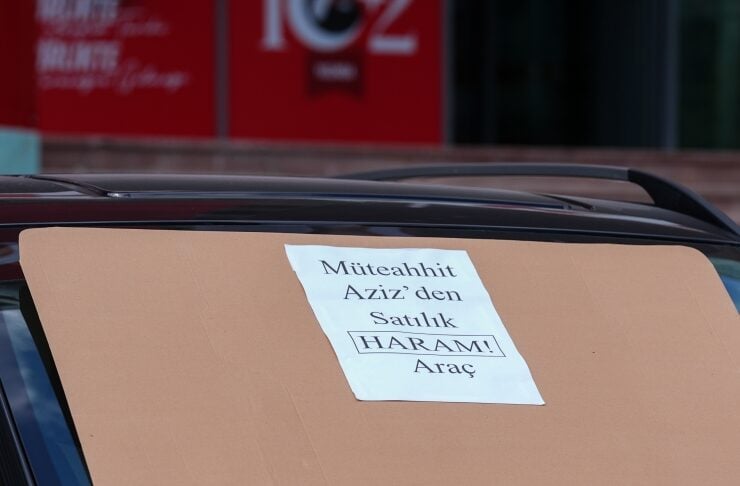 Car with a taped notice on the windshield reading: "Müteahhit Aziz'den Satılık HARAM! Araç" (for sale by contractor Aziz)