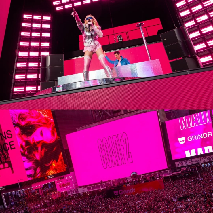 Pop singer on a bright pink-lit stage performing to a large crowd at a concert banquet.