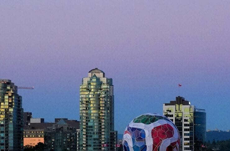 Dusk view of Vancouver with the colorful geodesic domed Science World by the water and city high-rises behind it