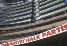 Facade of a tall office building with a large red and white sign reading Cumhuriyet Halk Partisi above the entrance.