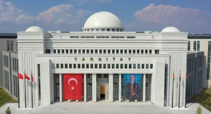 White government building with a domed roof and the word 'YARGITAY' on the façade, flanked by Turkish flags and large banners.
