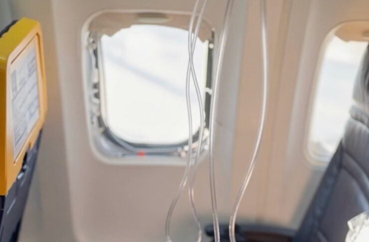 Airplane cabin seat with IV lines and medical bags hanging, suggesting in-flight medical care.